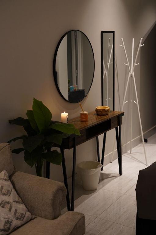 a room with a table with a mirror and a plant at Alsultan Cozy Studio in Al Khobar