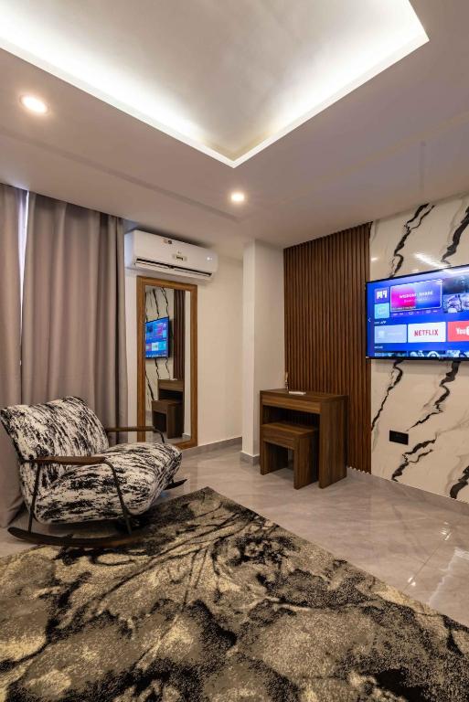 ein Wohnzimmer mit einem Sessel und einem großen Fernseher in der Unterkunft The Cabyn Boutique Hotel in Pantang