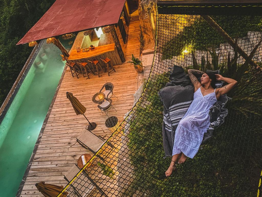 a woman laying on a bed next to a swimming pool at Casa A'more in Cuatunalco