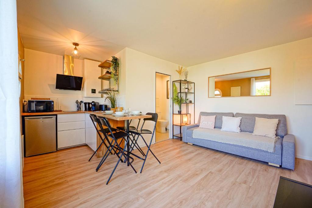 a living room with a couch and a table at Le Cocon à 15 minutes de Disneyland Paris in Bussy-Saint-Georges