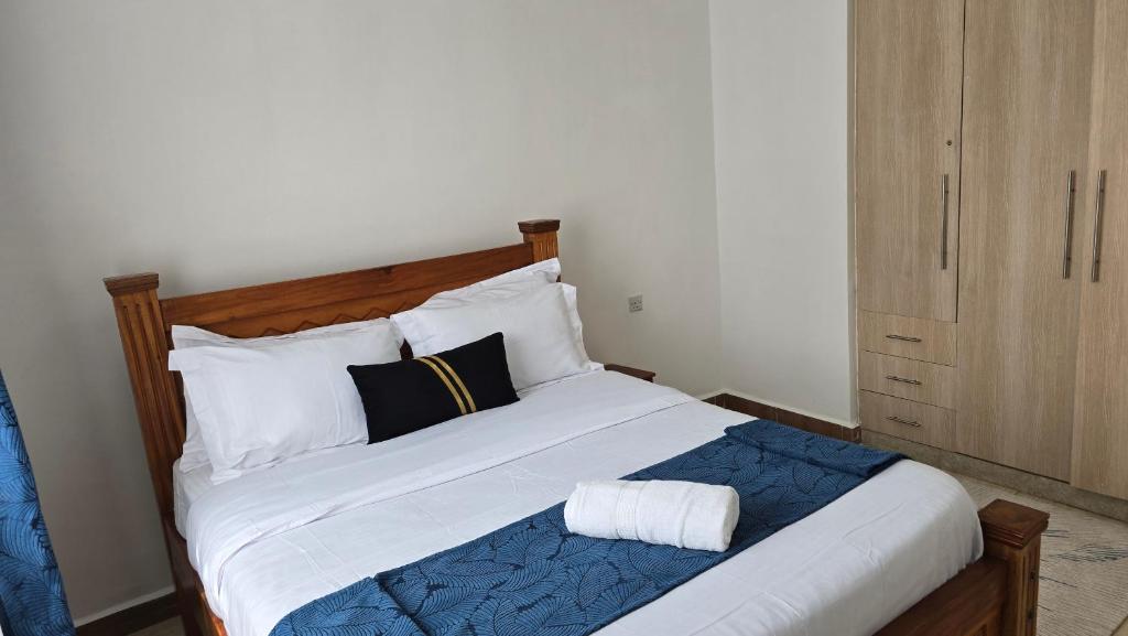 a bedroom with a large bed with white and black pillows at Tulivu homes in Ongata Rongai 