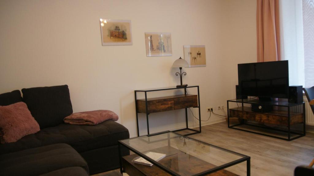a living room with a couch and a television at Ferienwohnung Gartenstraße in Mühlhausen
