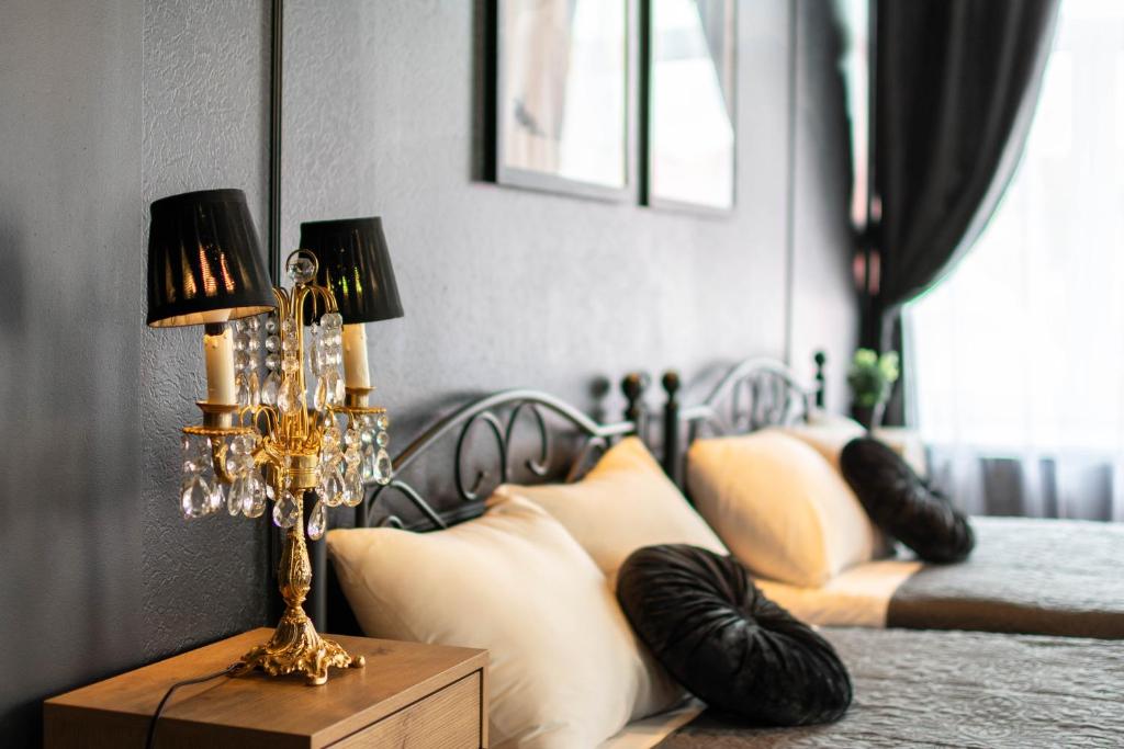 een slaapkamer met 2 bedden met kussens en een lamp bij Apartments24 Black 1903 in Rakvere