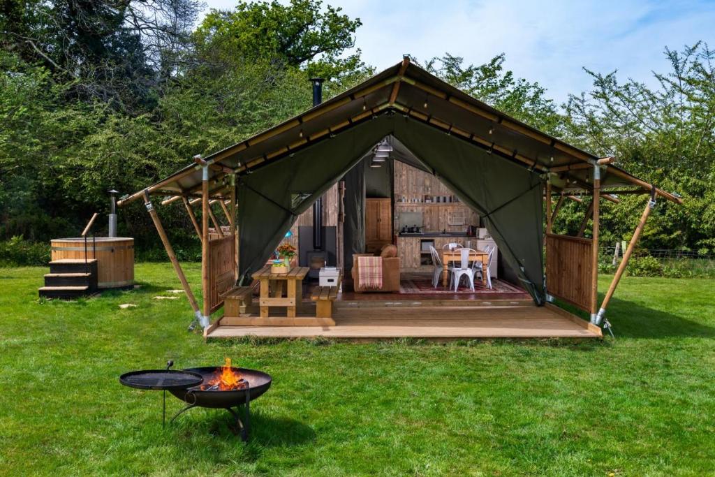 a green gazebo with a fire in the yard at Hebog Glamping Lodge in Talybont
