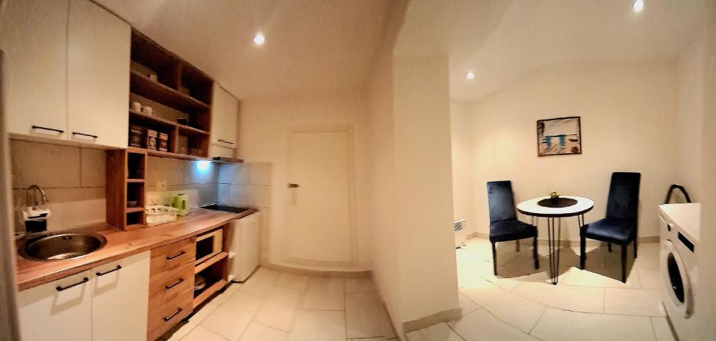 a kitchen with a table and two blue chairs at Apartman Magic moments Stari Grad in Trebinje