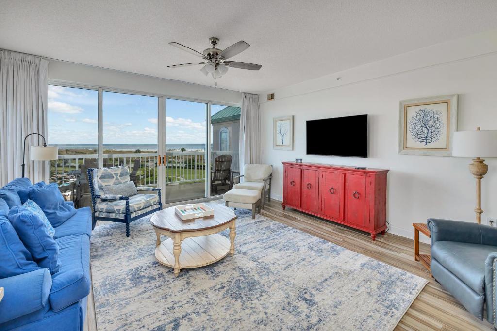 a living room with blue furniture and a flat screen tv at St. Simons Grand #305 in Saint Simons Island