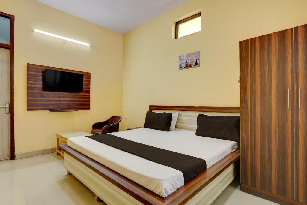 a bedroom with a large bed and a tv at Hotel O Namastay in Tapukrah
