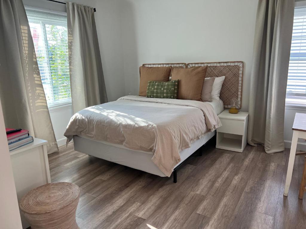 ein Schlafzimmer mit einem Bett und zwei Fenstern in der Unterkunft Charming Cozy Studio 5 Minutes from Sofi Stadium in Los Angeles