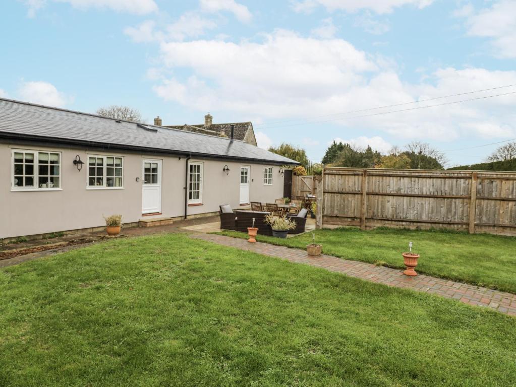 a garden with a white house and a fence at Rose Stables in Bampton