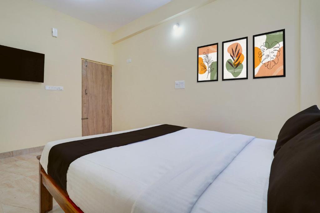 a bedroom with a bed and three pictures on the wall at Hotel O Kalpatharu Boarding and Lodging in Tyāmagondal