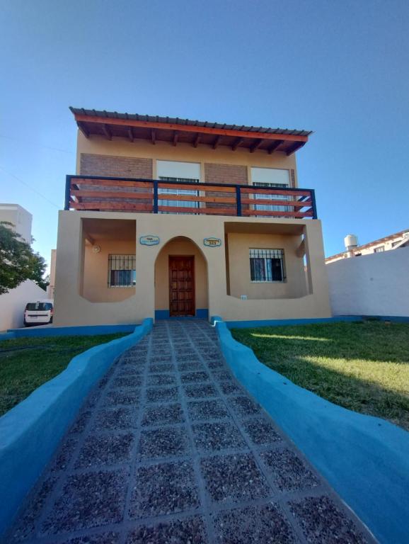 a house with a pathway in front of it at CASA AGUAS AZULES 6 pax LAS GRUTAS in Las Grutas