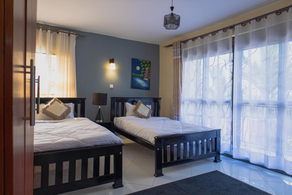 a bedroom with two beds and a window at MSGLakeview Guest House- Entebbe Bugiri in Kira