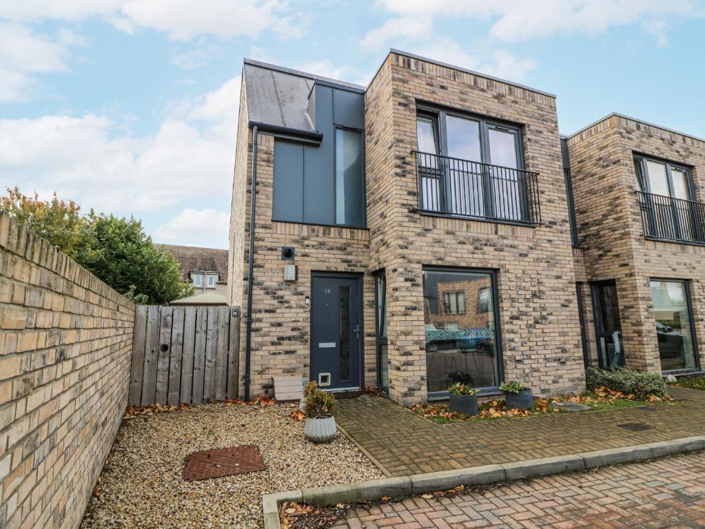 a brick house with black windows and a fence at 14 Old Market Place in Bonnyrigg