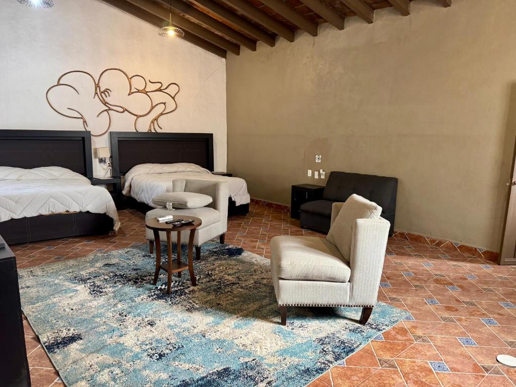 ein Zimmer mit zwei Betten und einem Tisch und Stühlen in der Unterkunft Galera centro de Tepoztlan in Tepoztlán