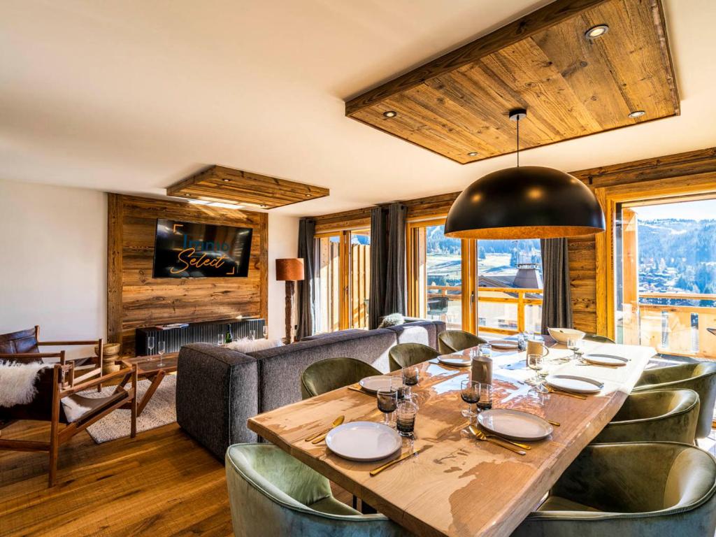 a dining room with a table and a couch at Appartement cosy en duplex, 8 pers, parking, Les Gets - FR-1-598-59 in Les Gets