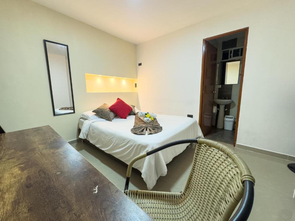 Un dormitorio con una cama con una mesa y una silla. en Montes De Beraka, en Minca