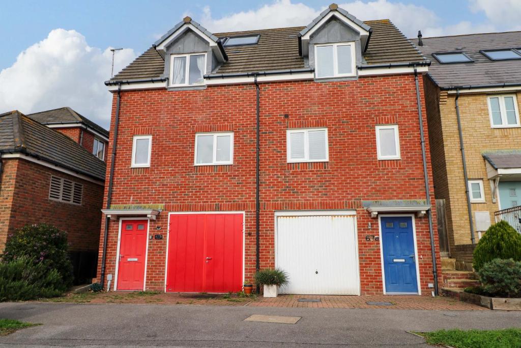 a red brick house with three garage doors at Harbour Way in Shoreham-by-Sea