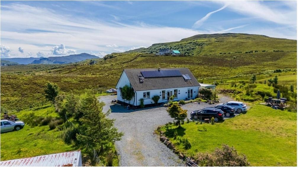 eine Luftaufnahme eines Hauses auf einem Hügel in der Unterkunft Burnside Cottage & Caravan Woodend in Portree