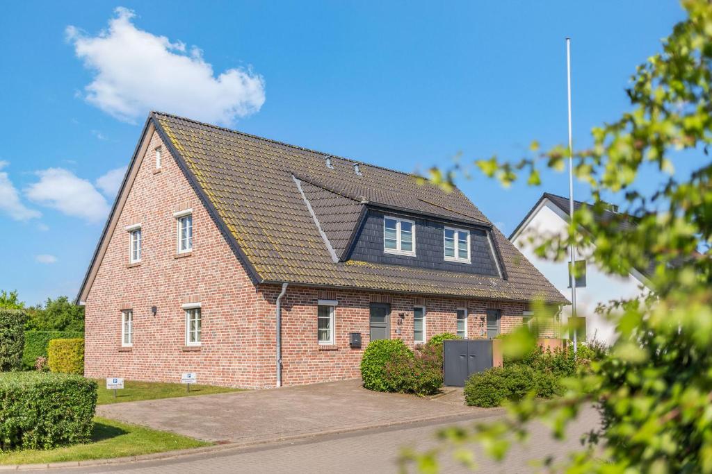 a red brick house with a black roof at Inselhuus Fehmarn 1 in Petersdorf auf Fehmarn