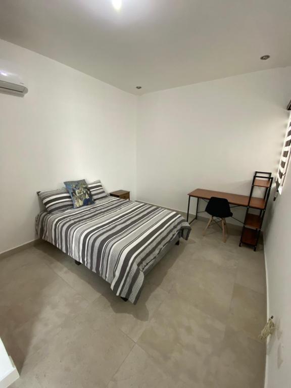 een witte kamer met een bed en een bureau bij Habitación cómoda y agradable in Monterrey