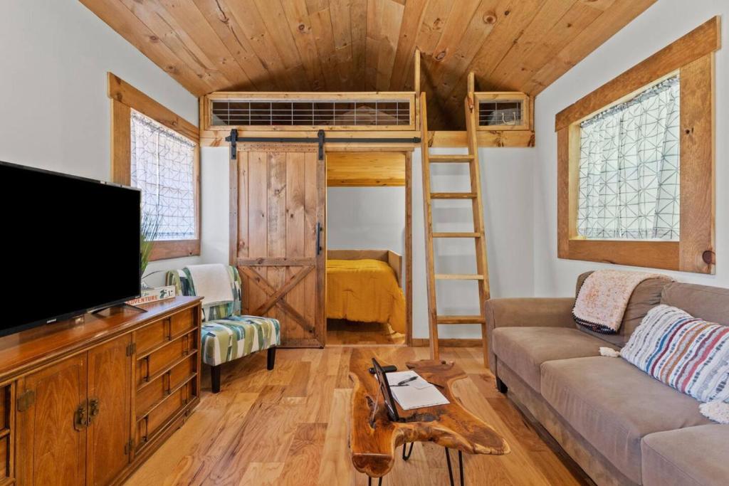 ein Wohnzimmer mit einem Sofa, einem TV und einem Etagenbett in der Unterkunft Hot Tub - Sit and Stay Cabin in Red River Gorge KY in High Falls