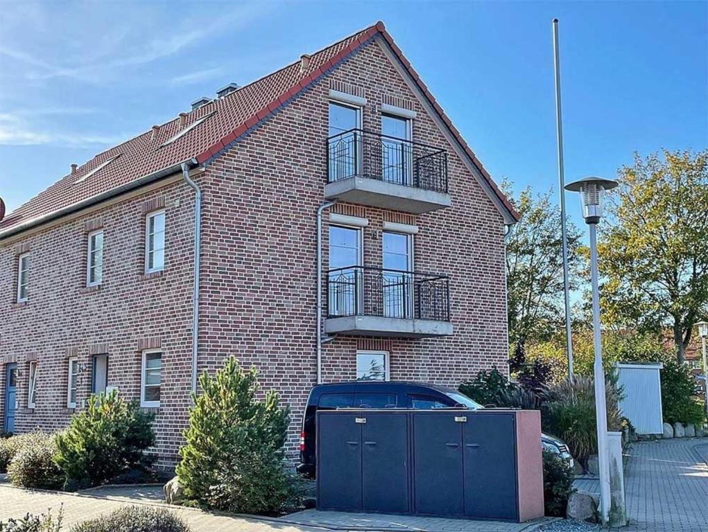 a brick house with a car parked in front of it at Haus Wellenkamp in Burg auf Fehmarn