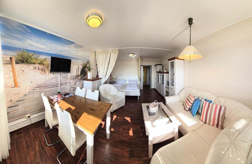 - un salon avec un canapé et une table à manger dans l'établissement OASE in Burgtiefe, à Burgtiefe auf Fehmarn 