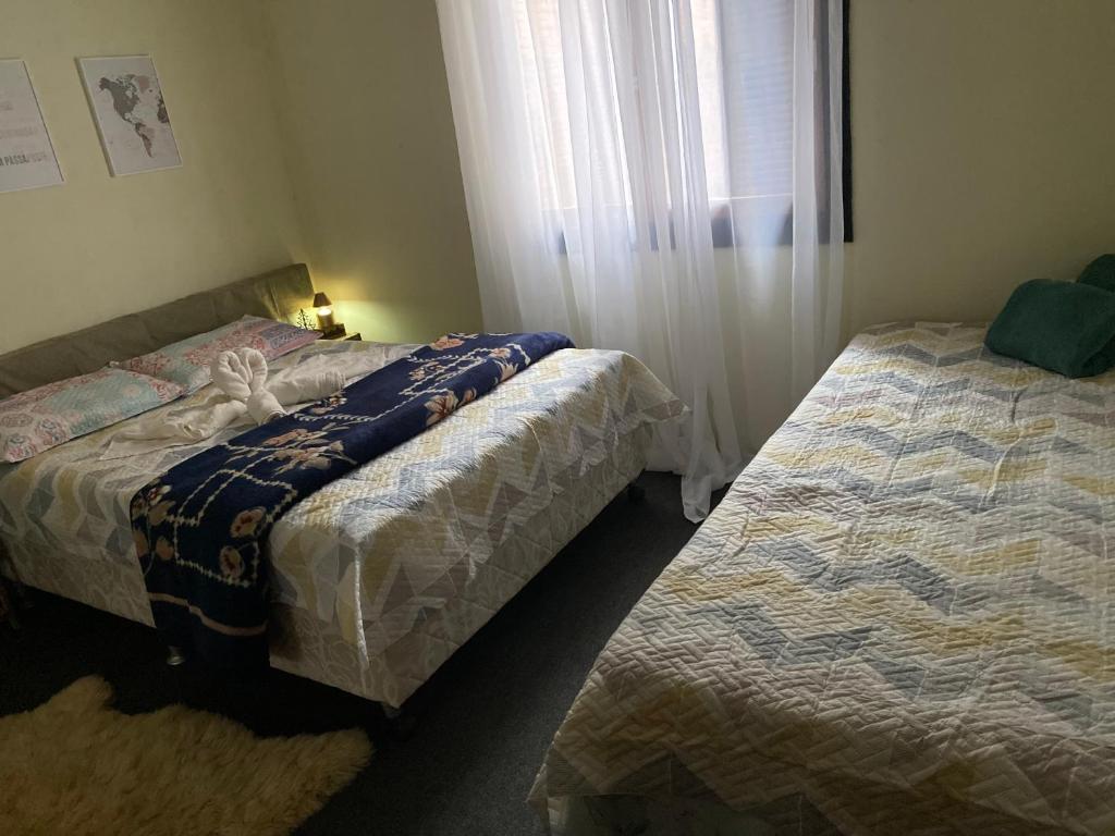 a bedroom with two beds and a window at Apzinho do Centro in Nova Petrópolis