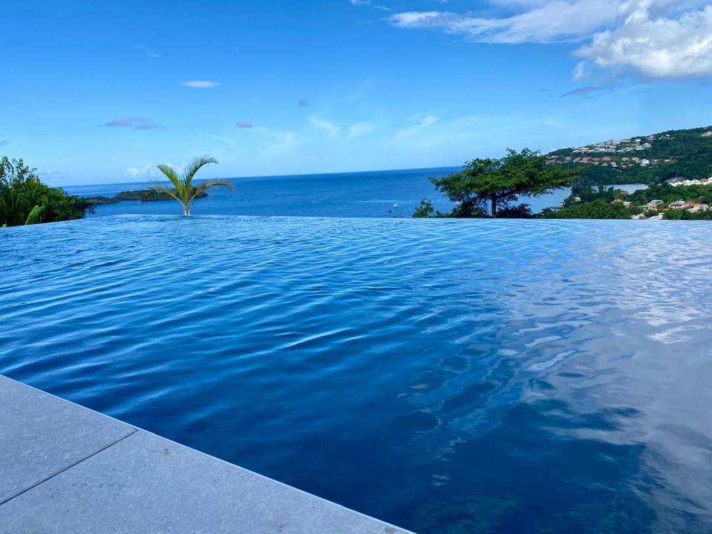 a swimming pool with a view of the ocean at Sunset Caraïbes in Bouillante