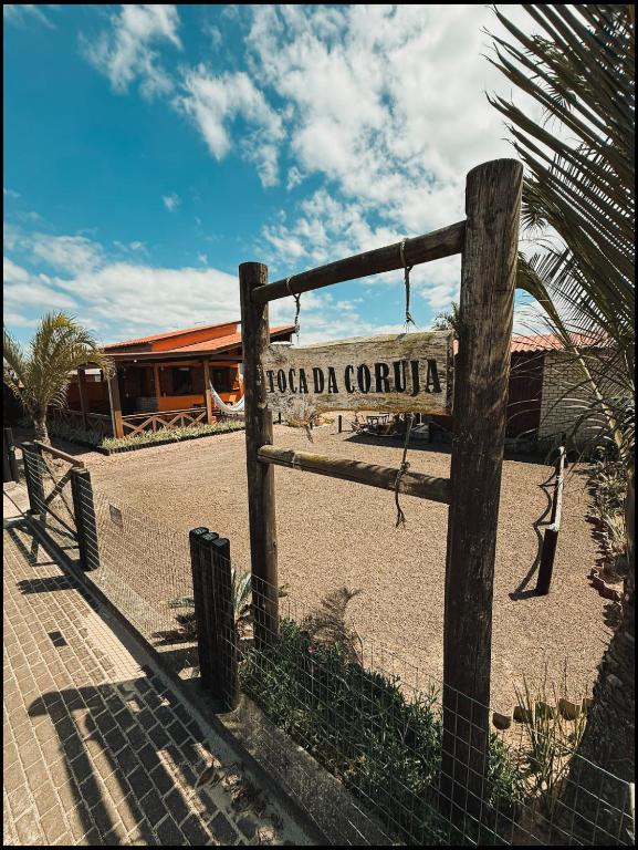 a sign on a fence in front of a building at Pousada Toca da Coruja Chales pequeno in Balneário Gaivotas