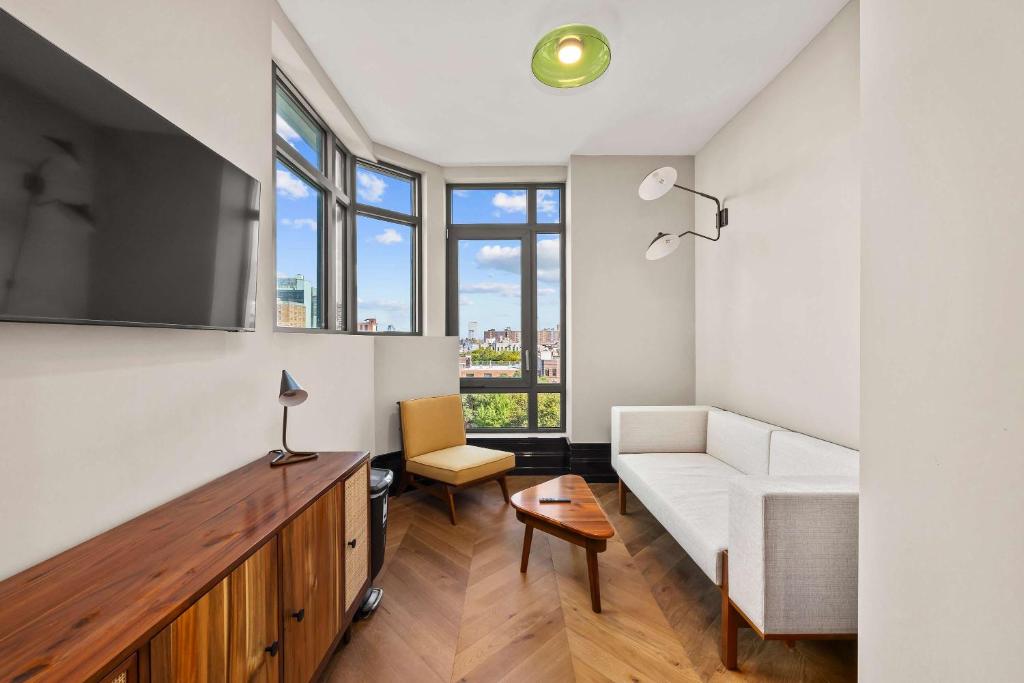 a living room with a couch and a table at Freeman 903 by Rove 1BR Condo with Shared Amenities in New York