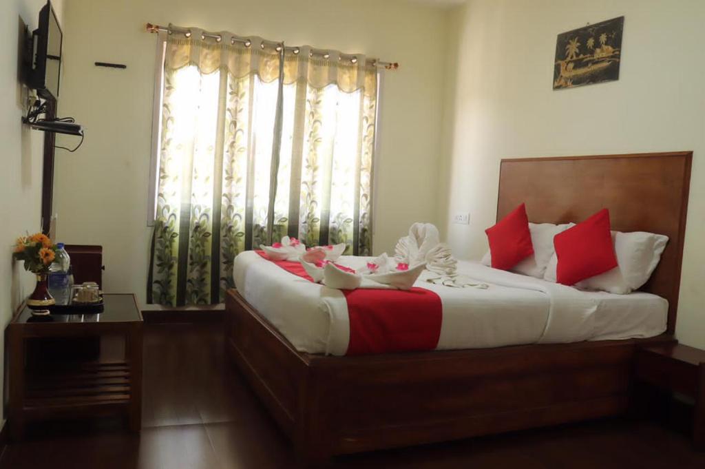 a bedroom with a large bed with red and white pillows at Life style home stay in Kodaikānāl
