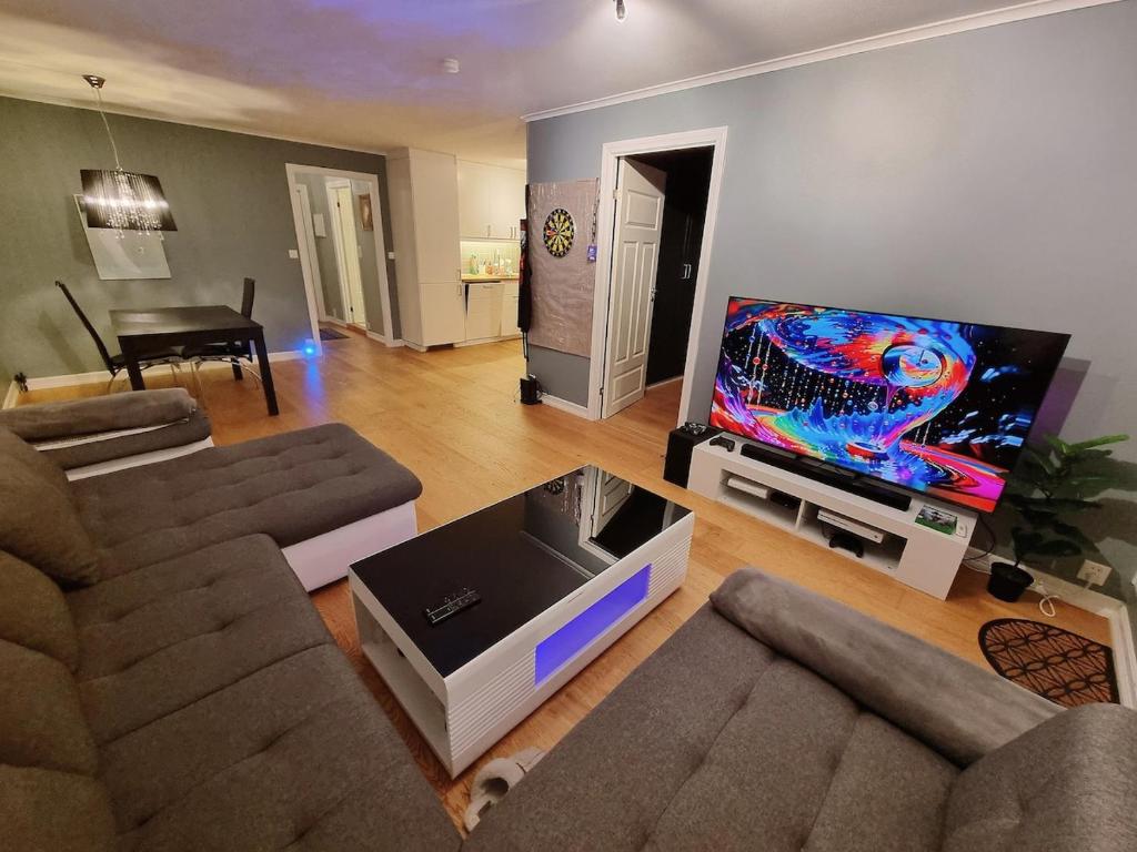 a living room with a couch and a flat screen tv at Beautiful 2-bedroom apartment in Bergen