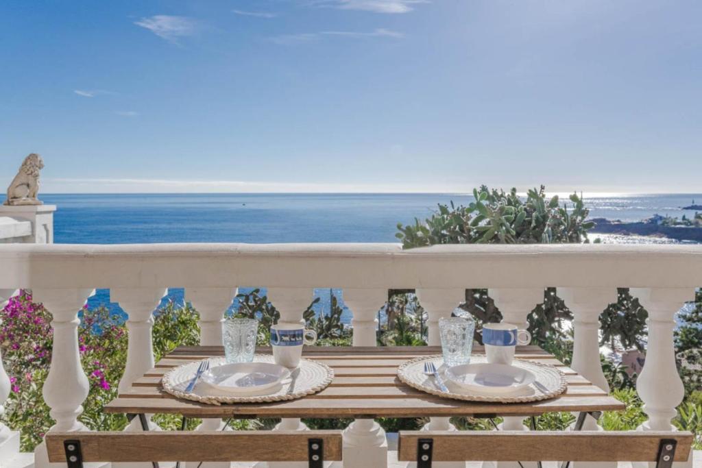 a table on a balcony with a view of the ocean at Petit Paradis vue Mer- Plage et calanques a 3 mn in Saint-Raphaël