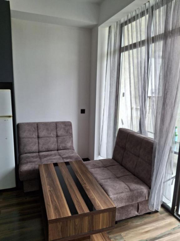 een woonkamer met een bank en een groot raam bij kut aguest house in Koetaisi