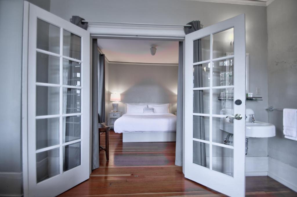 een slaapkamer met een bed en een badkamer met een wastafel bij Centralia Square Grand Ballroom and Vintage Hotel in Centralia