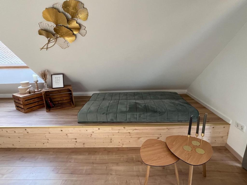 a bedroom with a green bed and two chairs at Gemütliche Ferienwohnung in Neustadt am Rübenberge in Neustadt am Rübenberge