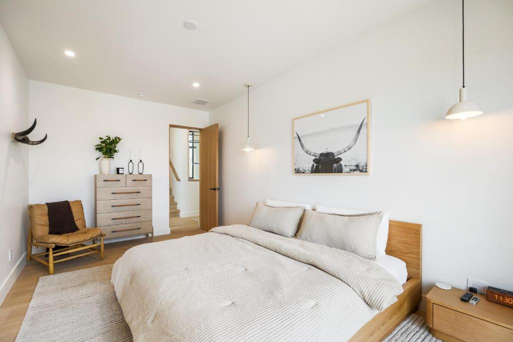 a white bedroom with a bed and a chair at Stunning Luxury Interiors, Jordanelle Views, Private Hot Tub, Sauna, Elite Locale! in Francis