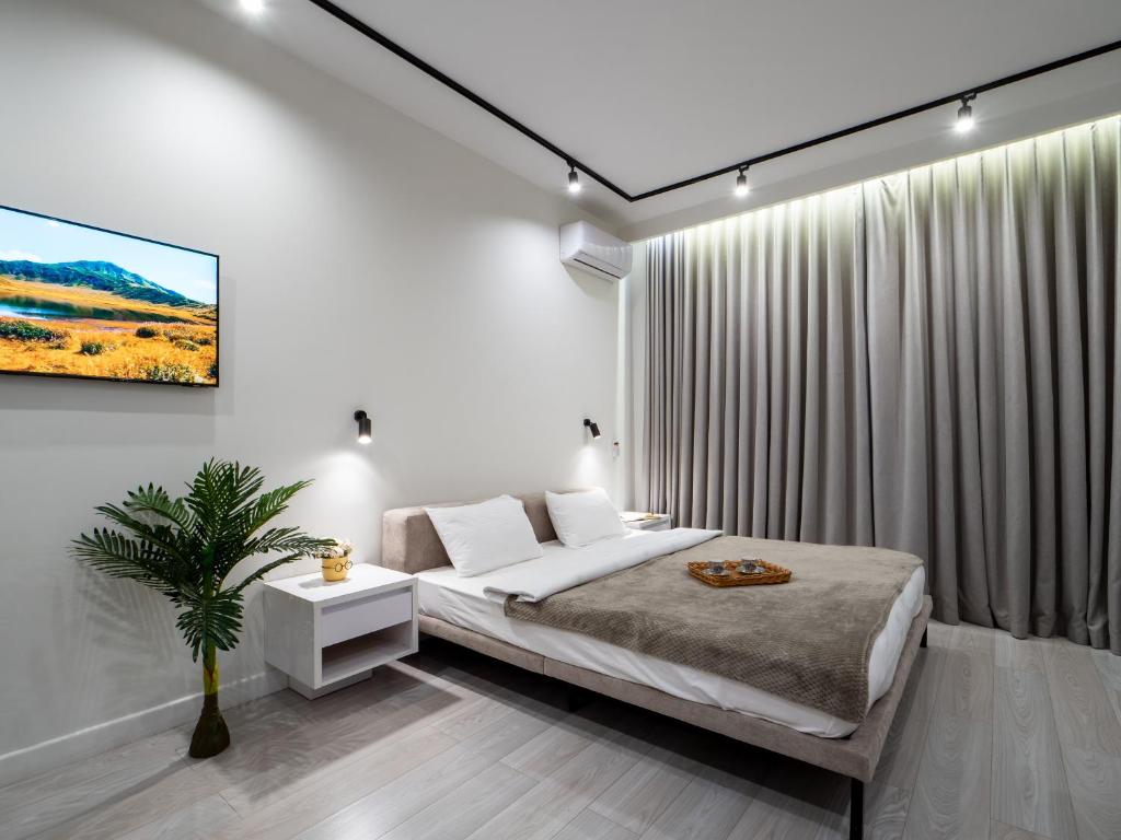 a bedroom with a bed and a painting on the wall at Seven Premium Apartments by Mega Mall in Almaty
