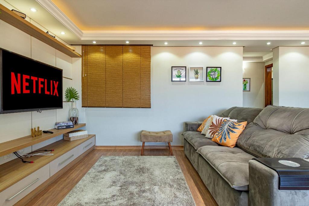 a living room with a couch and a tv at Imóvel bem localizado em Canela, cobertura in Canela