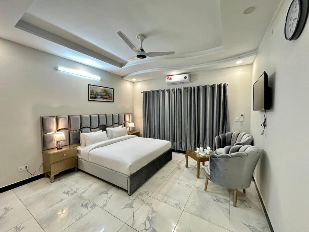 a bedroom with a bed and a chair and a television at Comfort Family Villa Islamabad in Islamabad