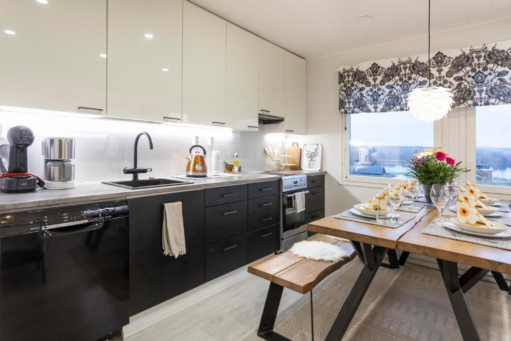 a kitchen with a wooden table and a dining room at Vasko Luxurious Suites, Firefox in Rovaniemi