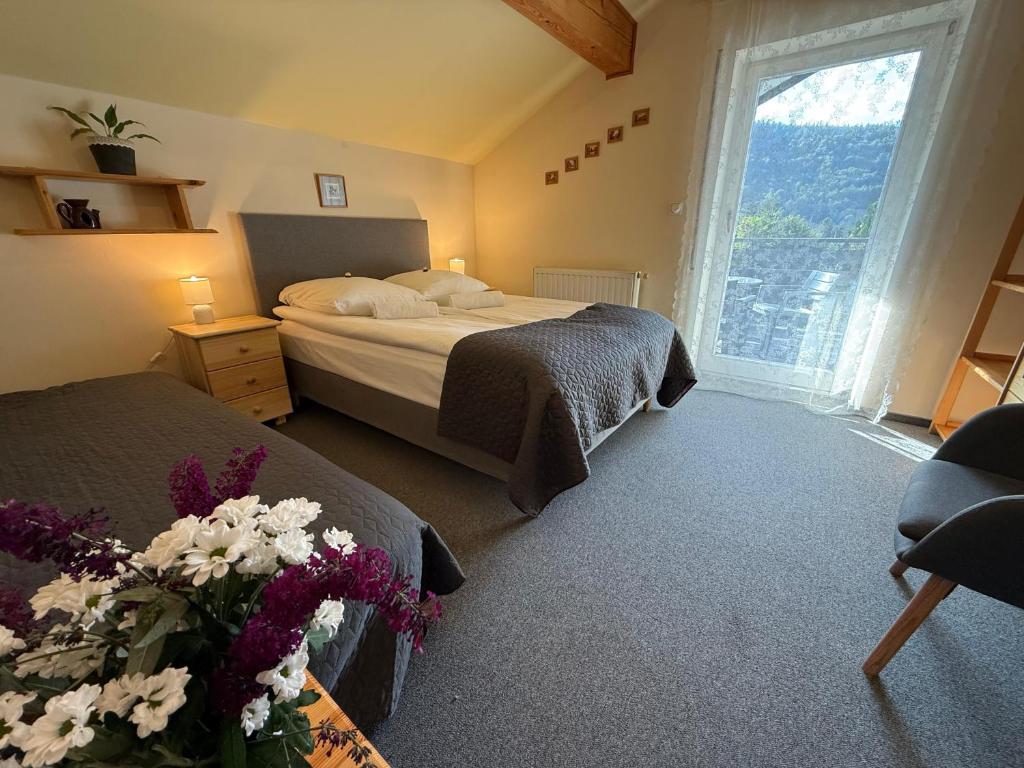een slaapkamer met twee bedden en een groot raam bij Apartamenty Czyrna przy Gondoli in Szczyrk