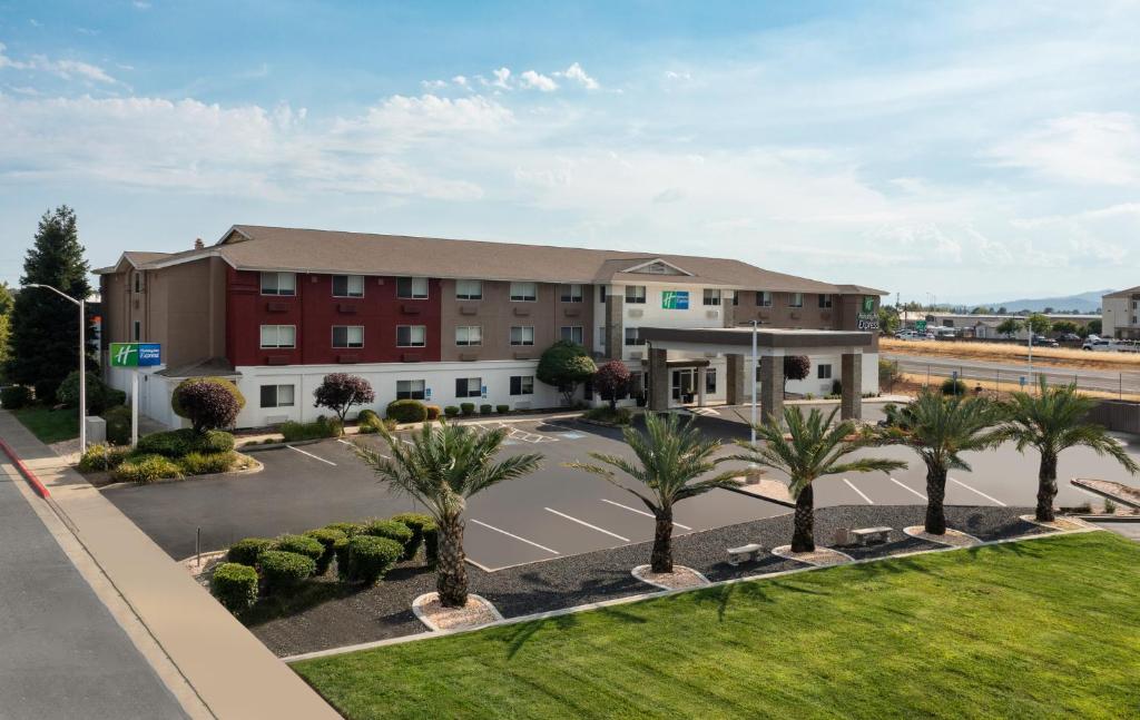 an aerial view of a hotel with palm trees at Holiday Inn Express Redding North by IHG in Redding