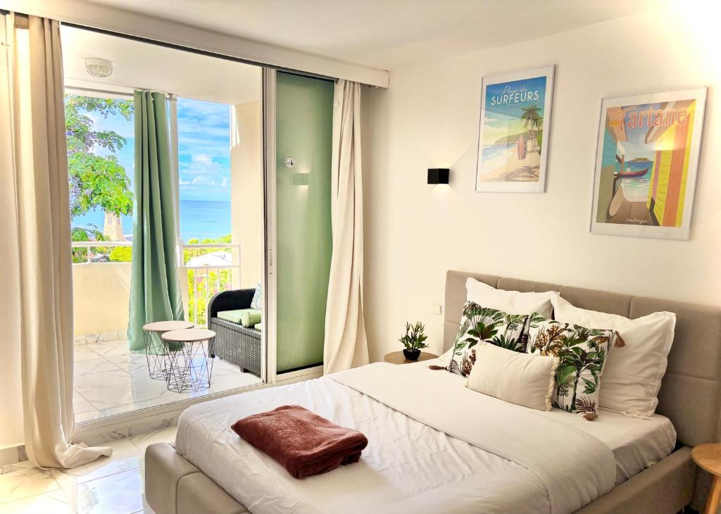 una camera da letto con un letto grande e un balcone di Studio bohème a La Trinité