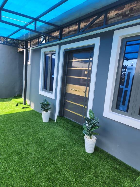 a house with two potted plants in front of it at Yinmic Homes in Ikorodu