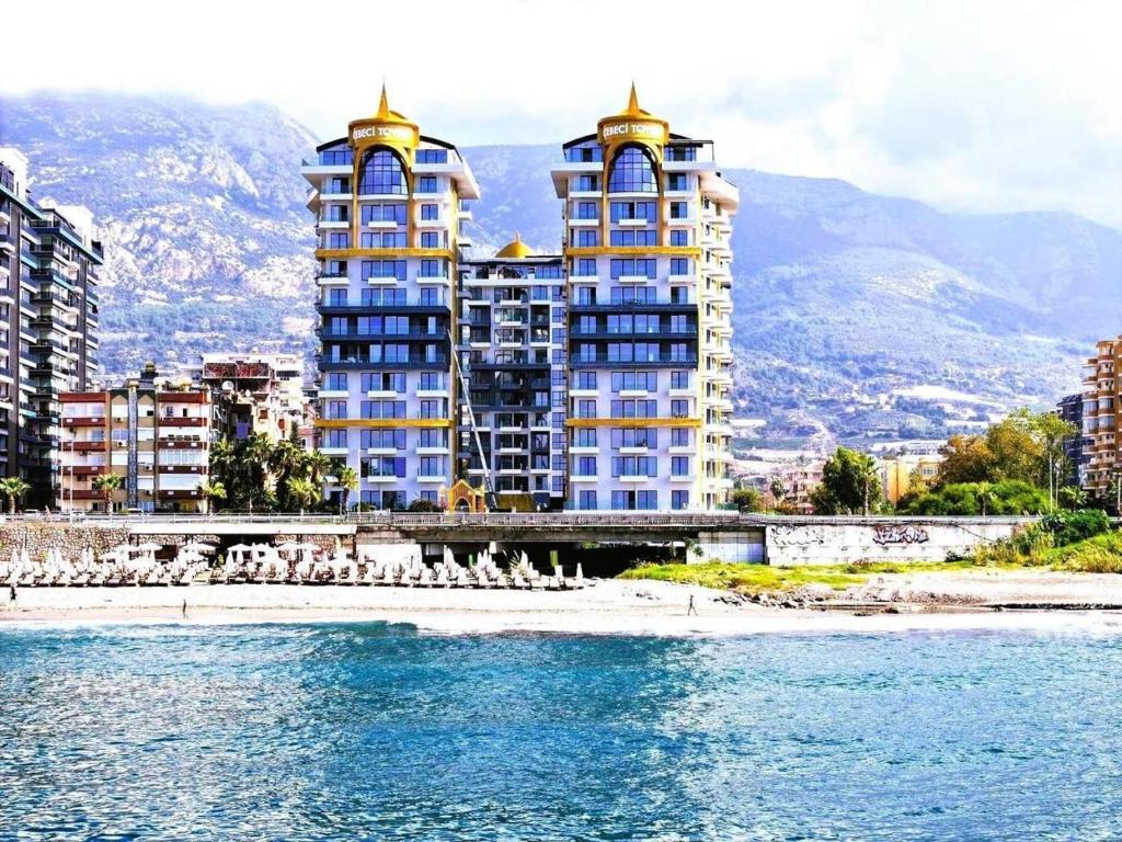 two tall buildings on a beach next to the water at Cebeci tower in Mahmutlar