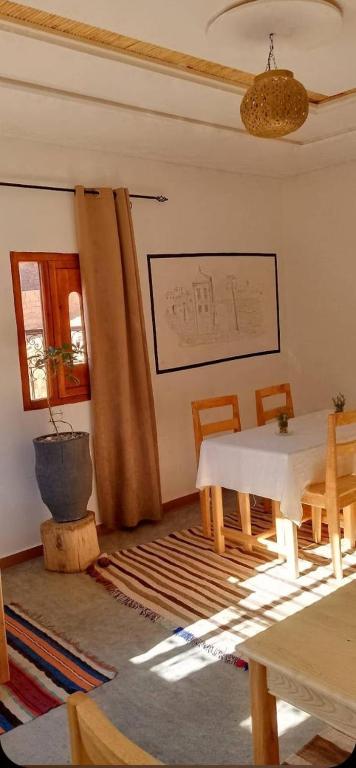 a living room with a table and chairs and a window at Riad La Belle Vue in Boumalne