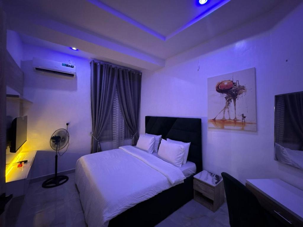a bedroom with a bed and a desk and a lamp at Smartlinks apartments in Ikota
