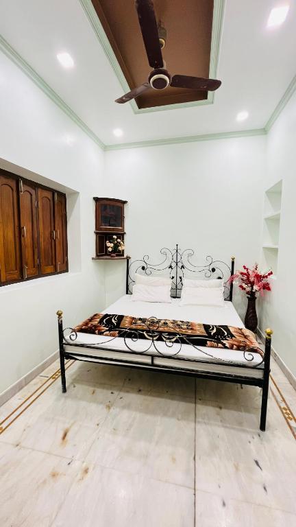 a bed in a room with a ceiling fan at Krishna guest house in Varanasi
